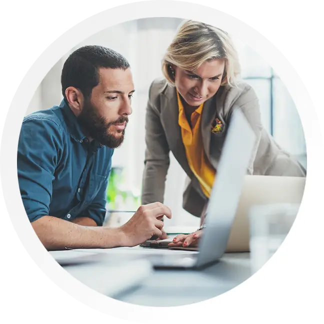 Man and women on a laptop using Knowtify.net regulatory data tools software.